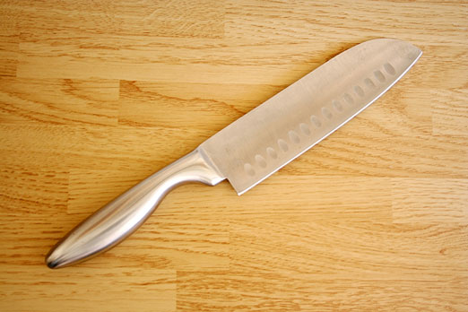santoku chef knife on a butcher block surface